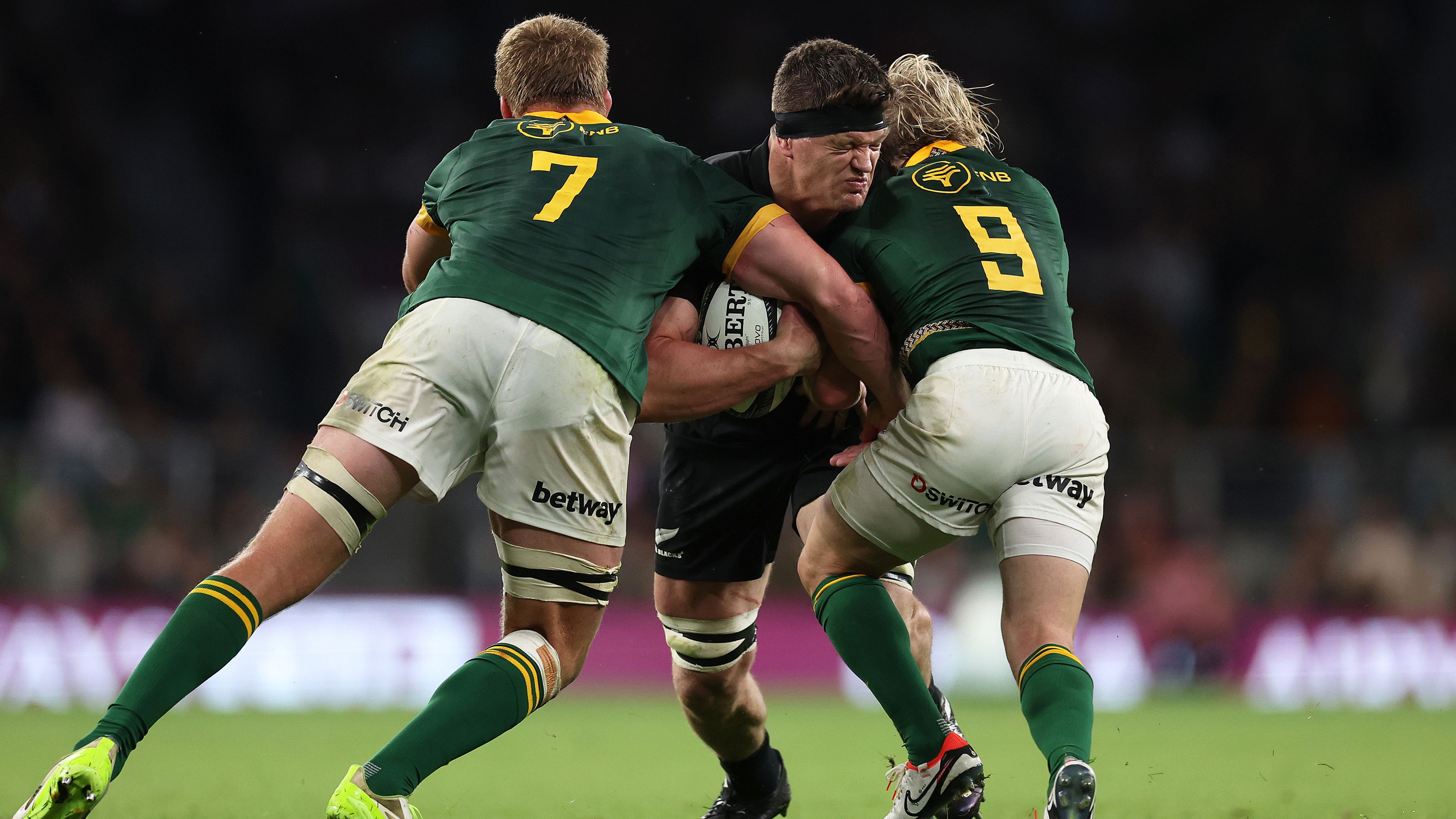 Scott Barrett of New Zealand is tackled by Pieter-Steph du Toit and Faf de Klerk of South Africa.